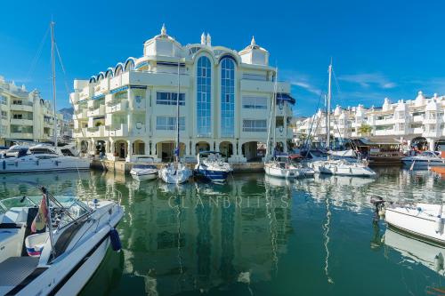 a large building with boats docked in a marina at Apartamento Marina Suite in Benalmádena