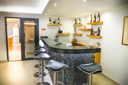 a kitchen with a bar with stools around it at Barreiros House in Funchal