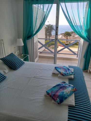 ein Schlafzimmer mit einem Bett mit Blick auf das Meer in der Unterkunft Sea front Villa Kristina in Klorakas