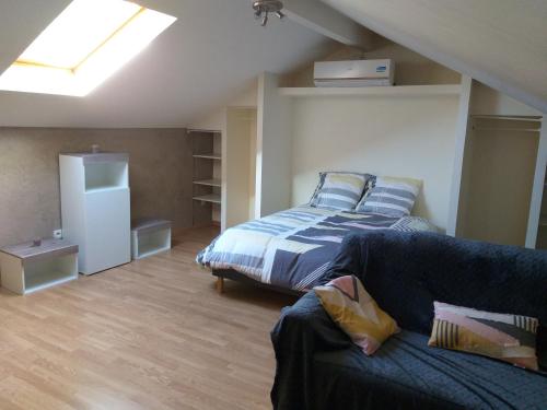 a bedroom with a bed and a couch in a room at Le Manant in Bellegarde-sur-Valserine