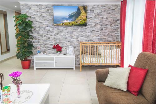 a living room with a couch and a stone wall at Barreiros House in Funchal