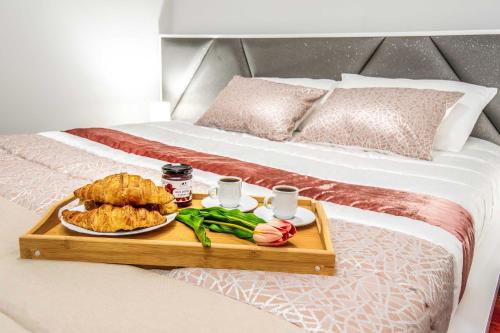 a tray with food and drinks on a bed at Barreiros House in Funchal