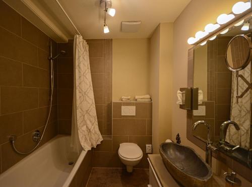a bathroom with a sink and a toilet and a tub at ABACCO Ferienwohnungen in Überlingen