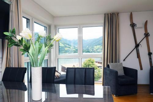 a dining room with a table and a large window at Alpin & See Resort - Pinzgau Holidays in Zell am See