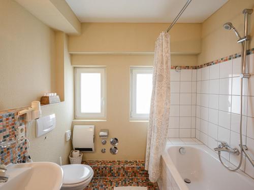 a bathroom with a tub and a toilet and a sink at ABACCO Ferienwohnungen in Überlingen