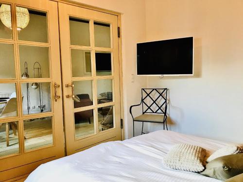 a bedroom with a bed and a tv on the wall at Naabsuite in Neustadt an der Waldnaab
