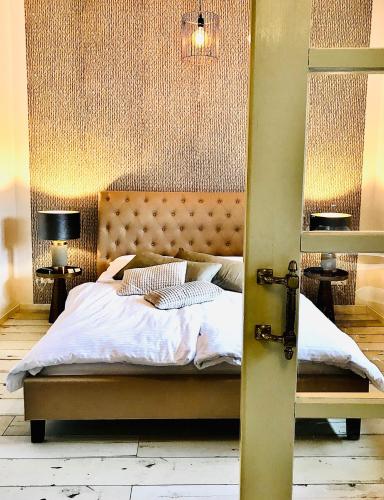 a bedroom with a large bed with a padded headboard at Naabsuite in Neustadt an der Waldnaab