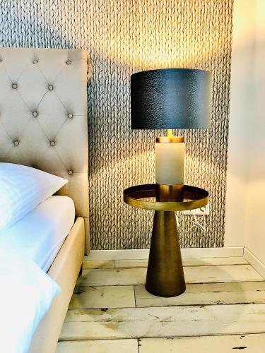 a lamp on a table next to a bed at Naabsuite in Neustadt an der Waldnaab
