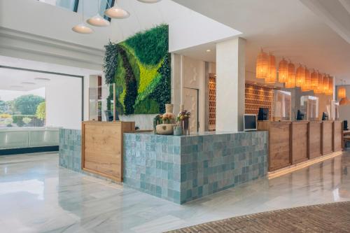 a lobby of a hotel with a green wall at Iberostar Waves Royal Andalus in Chiclana de la Frontera