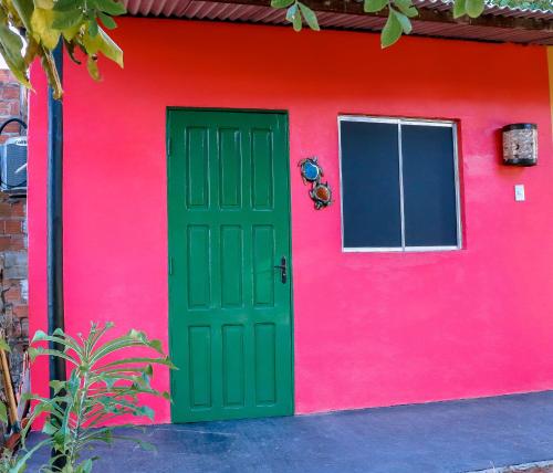 a red house with a green door and a red wall at Casa do Mestre Avila in Jijoca de Jericoacoara