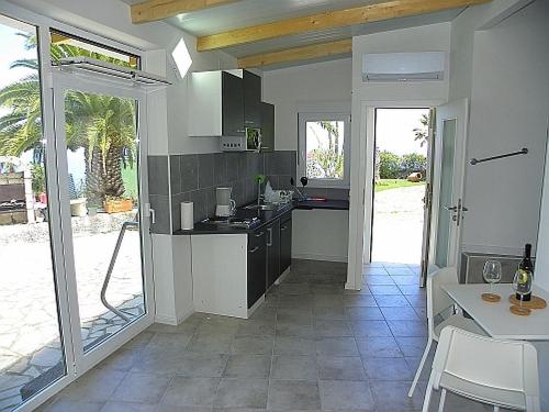 a kitchen with a sink and a table with chairs at Casita Mariposa Azul in Icod de los Vinos