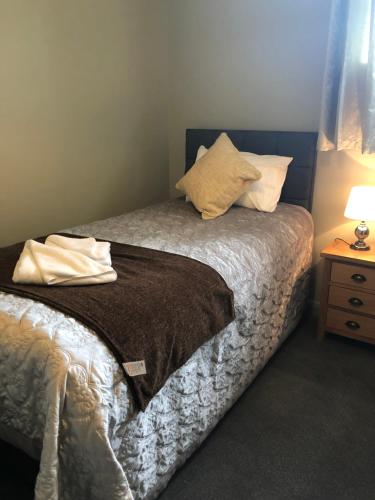 a bedroom with a bed and a night stand with a lamp at Al Forno Restaurant & Inn in Norwich