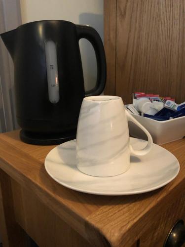 a cup on a plate on a counter with a pot at Al Forno Restaurant & Inn in Norwich
