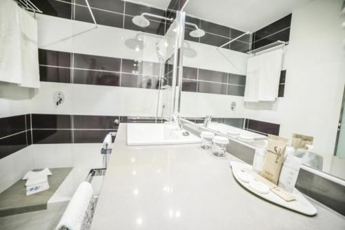 a white bathroom with two sinks and a mirror at Hotel Beatriz Playa & Spa in Puerto del Carmen