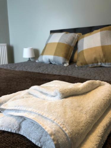 a towel is sitting on a bed with pillows at Al Forno Restaurant & Inn in Norwich