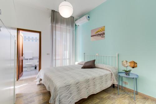 a bedroom with a bed and a mirror and a bathroom at Battigia Rimini - Appartamenti Vacanze in Rimini