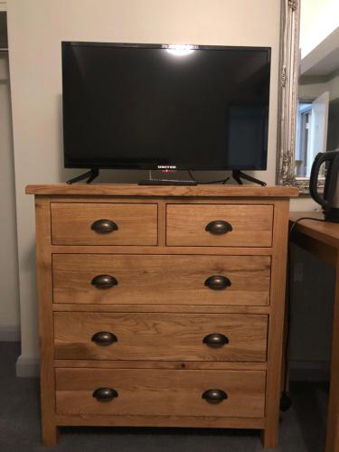 a television on top of a wooden dresser at Al Forno Restaurant & Inn in Norwich
