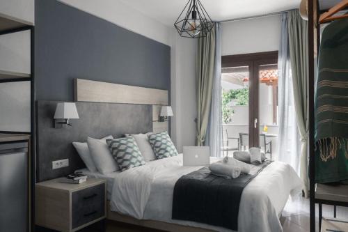 ein Schlafzimmer mit einem Bett und einem Laptop darauf in der Unterkunft Meliton Inn Hotel & Suites by the beach in Neos Marmaras