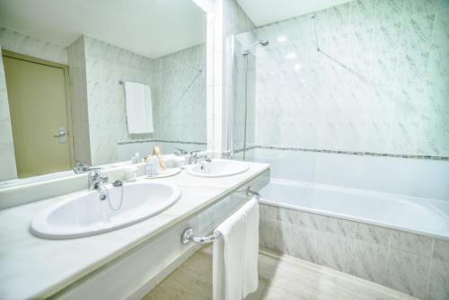 
a bathroom with two sinks and a mirror at Hotel Beatriz Playa & Spa in Puerto del Carmen

