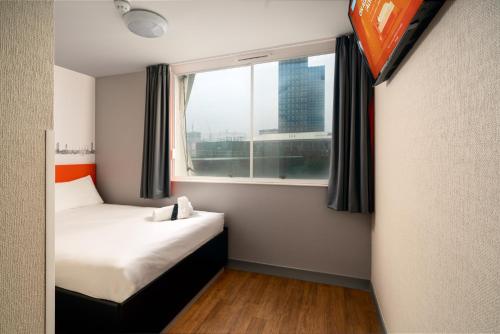 Habitación pequeña con cama y ventana en easyHotel Croydon, en Croydon