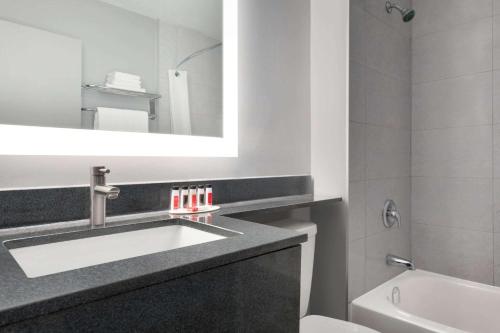 a bathroom with a sink and a mirror at Super 8 by Wyndham Windsor/Dougall in Windsor