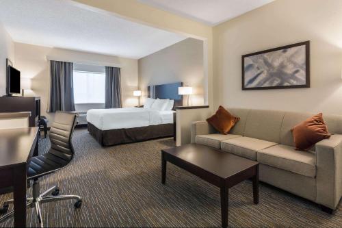 a hotel room with a couch and a bed at Wingate by Wyndham Gurnee in Gurnee