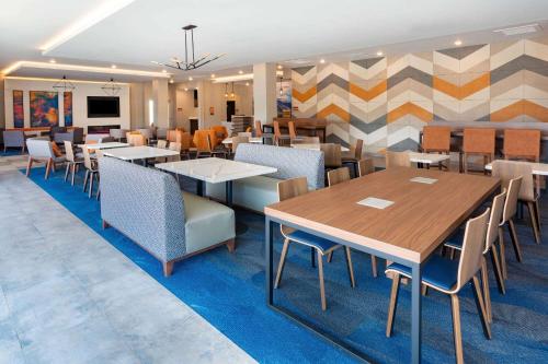 un comedor con mesas y sillas en La Quinta Inn & Suites Limon by Wyndham, en Limon