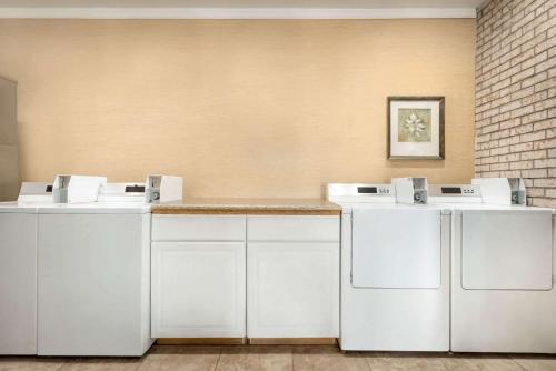 una fila de lavadoras blancas en una habitación en Days Inn by Wyndham Whitmore Lake, en Whitmore Lake