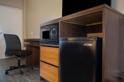 a black refrigerator in a cabinet with a microwave at Super 8 by Wyndham Mobile I-65 in Mobile