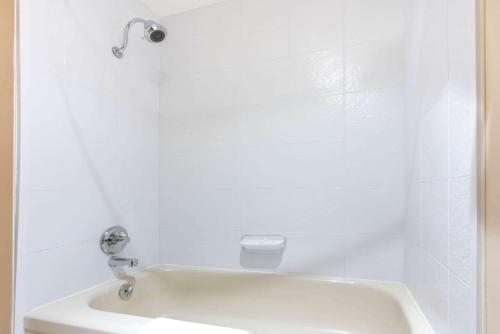 a bathroom with a white tub and a sink at Ramada by Wyndham Coquitlam in Coquitlam