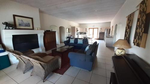 a living room with blue furniture and a fireplace at Barton Luxury Villas in Botrivier