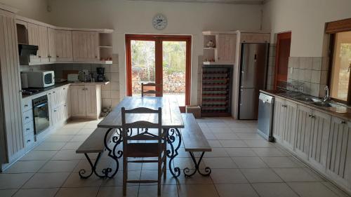 a kitchen with a table and chairs in it at Barton Luxury Villas in Botrivier