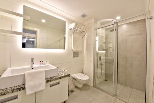 een badkamer met een wastafel, een toilet en een douche bij Green Garden Suites Hotel in Alanya