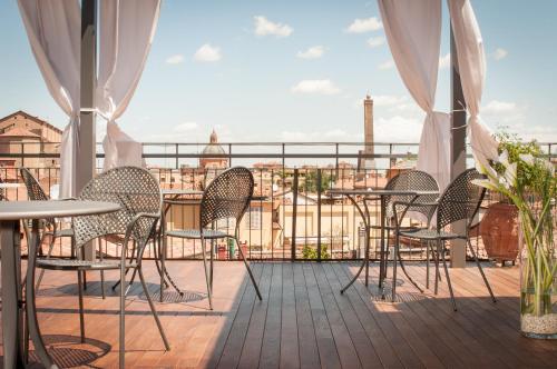 a balcony with tables and chairs and a view of the city at Hotel Touring in Bologna