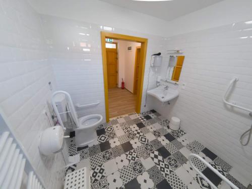 a white bathroom with a toilet and a sink at Kun Pista Vendégház in Vértesboglár