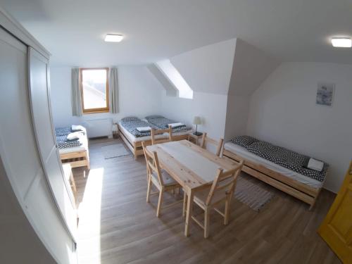 a room with three beds and a table and chairs at Kun Pista Vendégház in Vértesboglár
