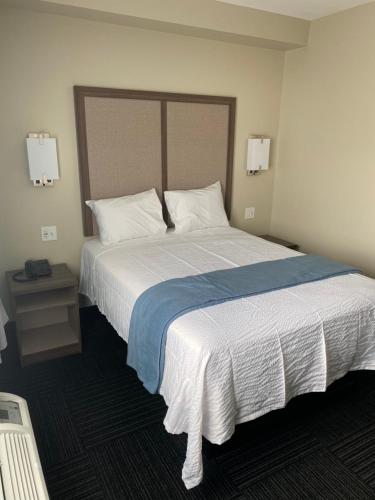 a bedroom with a large bed with white sheets and pillows at Hotel DeSoto in Olive Branch