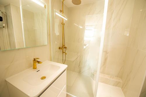 une salle de bain blanche avec un lavabo et une douche dans l'établissement THEATRE 12 - Dijon Hyper Centre Appartement T2 Face Musée, Monuments et Restaurants, à Dijon