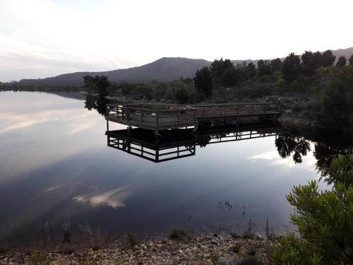 a dock in the middle of a lake at Barton Luxury Villas in Botrivier