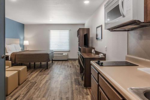 a kitchen and living room with a bed in a room at WoodSpring Suites North Ft Worth Alliance TX Speedway in Fort Worth