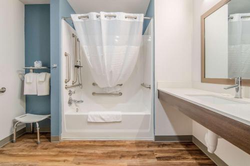 a bathroom with a shower and a sink at WoodSpring Suites North Ft Worth Alliance TX Speedway in Fort Worth