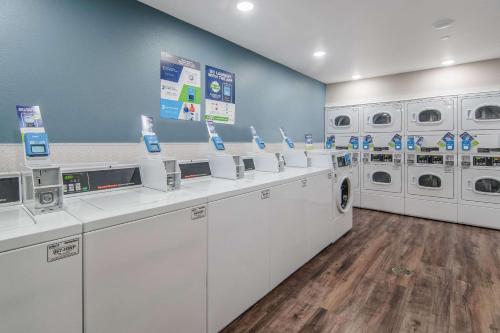 a laundry room with white washers and dryers at WoodSpring Suites North Ft Worth Alliance TX Speedway in Fort Worth