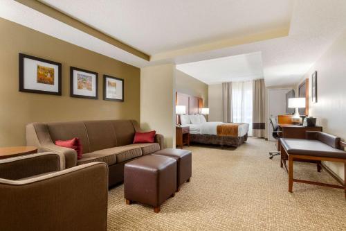 Comfort Inn & Suites Cordele في كورديل: غرفة في الفندق مع أريكة وسرير