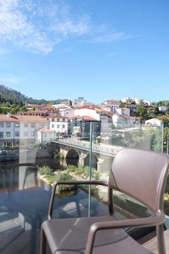a chair on a balcony with a view of a bridge at Hotel Vouga in Termas de Sao Pedro do Sul