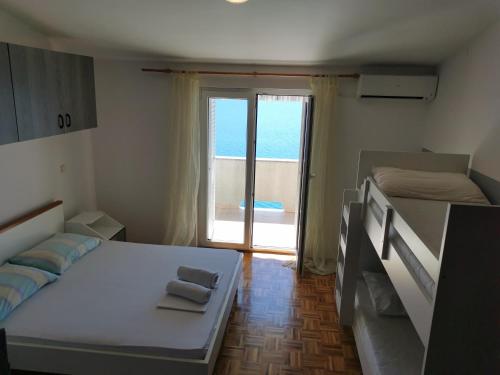 a bedroom with two beds and a view of the ocean at Apartments Galinec in Metajna