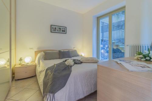 een slaapkamer met een groot bed en een groot raam bij La Dolce Vista in Perledo