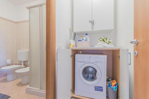 een badkamer met wasmachine en toilet bij La Dolce Vista in Perledo