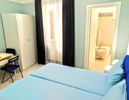 a bedroom with a bed and a desk and a bathroom at Hello B&B in Acitrezza