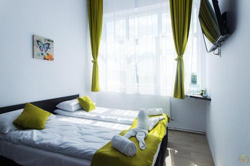 a bedroom with a bed with yellow curtains and a window at Antari in Slatina