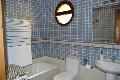 a blue tiled bathroom with a toilet and a sink at FANTASTICAS CASAS RURALeS in Barbate